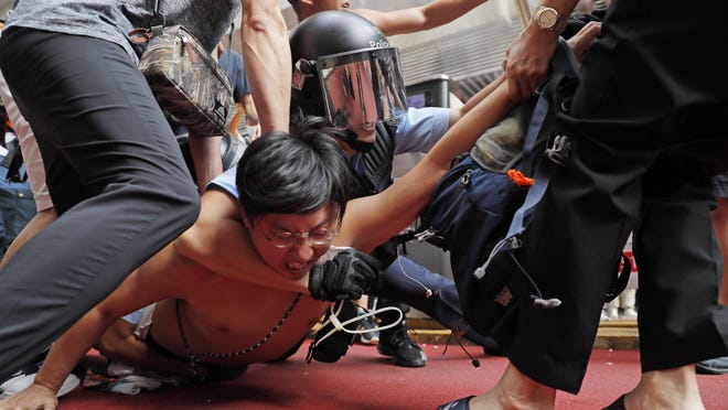 Police detain a man after fights broke out between pro-China supporters and anti-government protesters outside the Amoy Plaza in the Kowloon Bay district in Hong Kong.