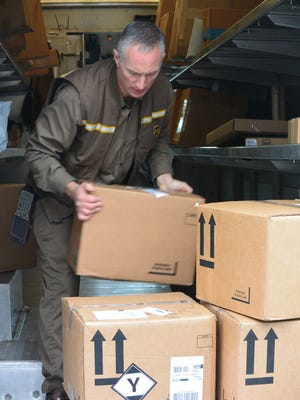 Dwight Patton, a UPS driver, works on his busy route in Asheville during the holiday season.