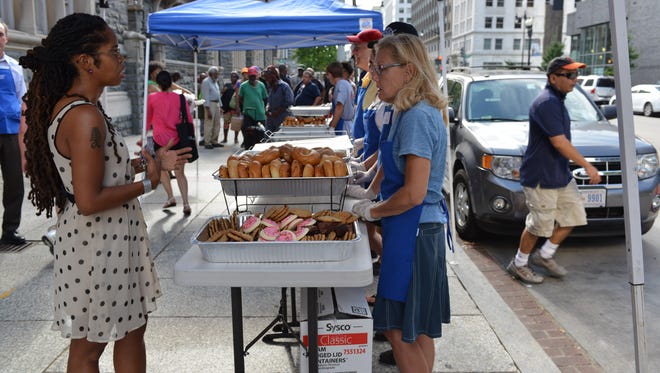 Catholic Charities Program Director Lydia Pearl Monroe, left, instructs volunteers who help serve food from the St. Maria's Meals truck in front of Catholic Charities for the Archdiocese of Washington.