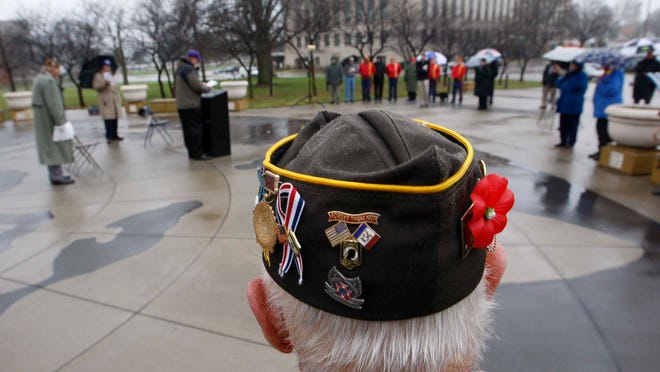 
A veteran sports a poppy along with pins and patches on his hat during a Veteran's Day Ceremony at the World War II memorial near the Iowa Statehouse on Nov. 11, 2008.
