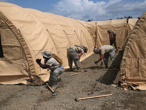 U.S. Air Force personnel put up tents to house a 25-bed