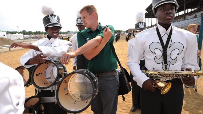 Tech High School’s band director, Brandon Anderson, is shown giving advice to one of his students before Tech performed at the Indiana State Fair Band Day competiion in 2013. This year was the third year the high school participated.