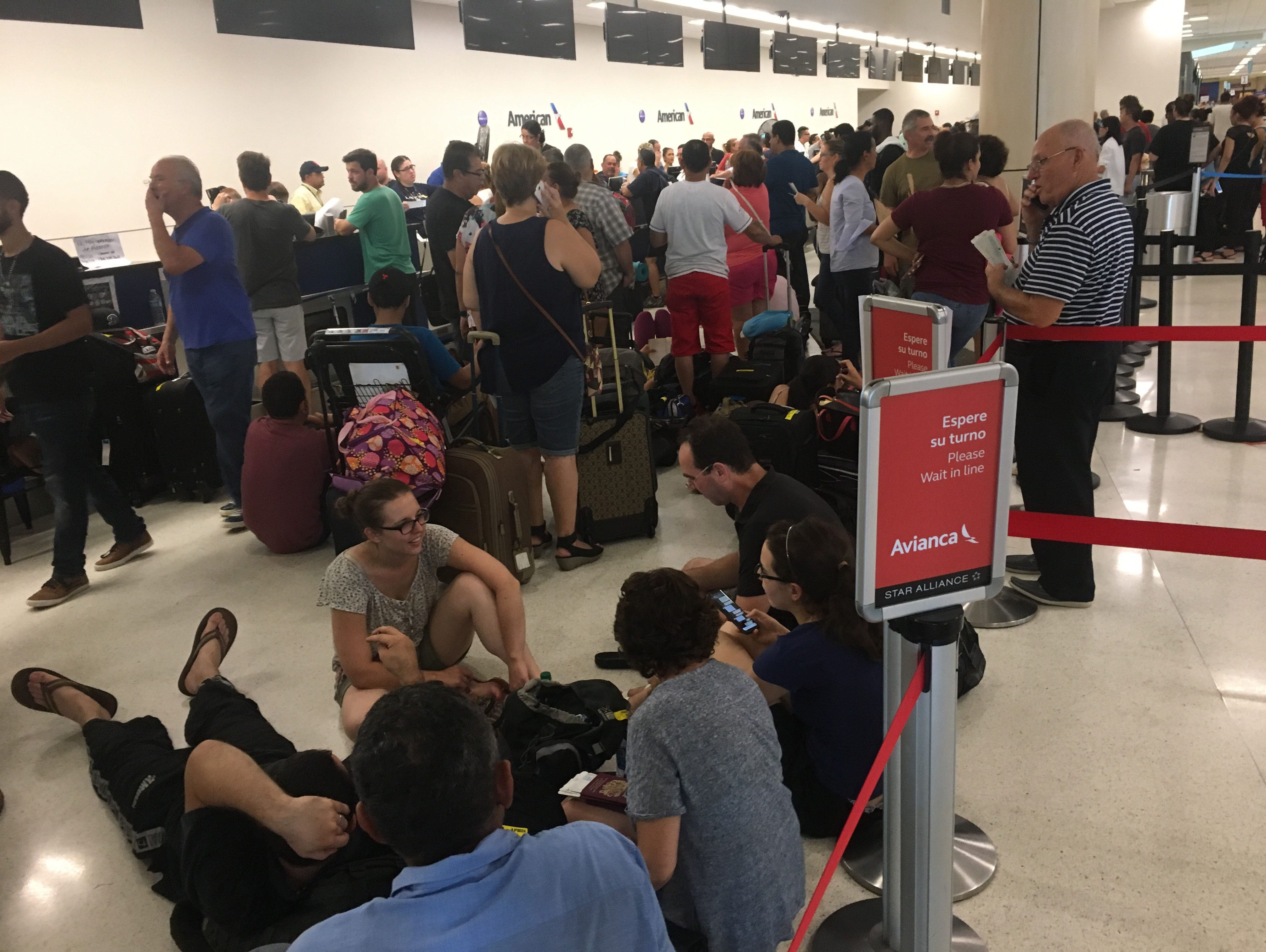 Travelers at San Juan Luis Muñoz Marín Airport wait to hear whether they've made it on a flight off the island. Flights were canceled for days after Hurricane Maria tore through Puerto Rico last week, knocking out power across the island.