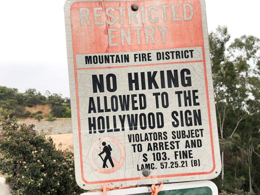 Signs tell tourists they can't hike to the sign, but