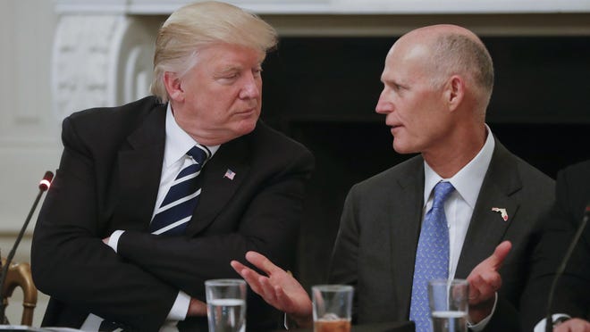 President Donald Trump listens to Florida Gov. Rick Scott, right, during an Infrastructure Summit at the White House on Thursday.