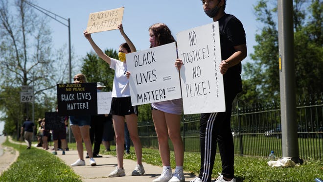 Payton Lowry, right, stands with sisters Norah and Anna Pevey as they participate in a Black Lives Matter protest at the intersection of West Morton Avenue and South Main Street in Jacksonville on Sunday. The hours-long protest drew more than 200 people from Jacksonville and the surrounding communities.