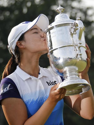 South Korea's In Gee Chun kisses the championship trophy after winning the U.S. Women's Open golf tournament at Lancaster Country Club, Sunday, July 12, 2015 in Lancaster, Pa. Chun won by one stroke over second place finisher Amy Yang.
