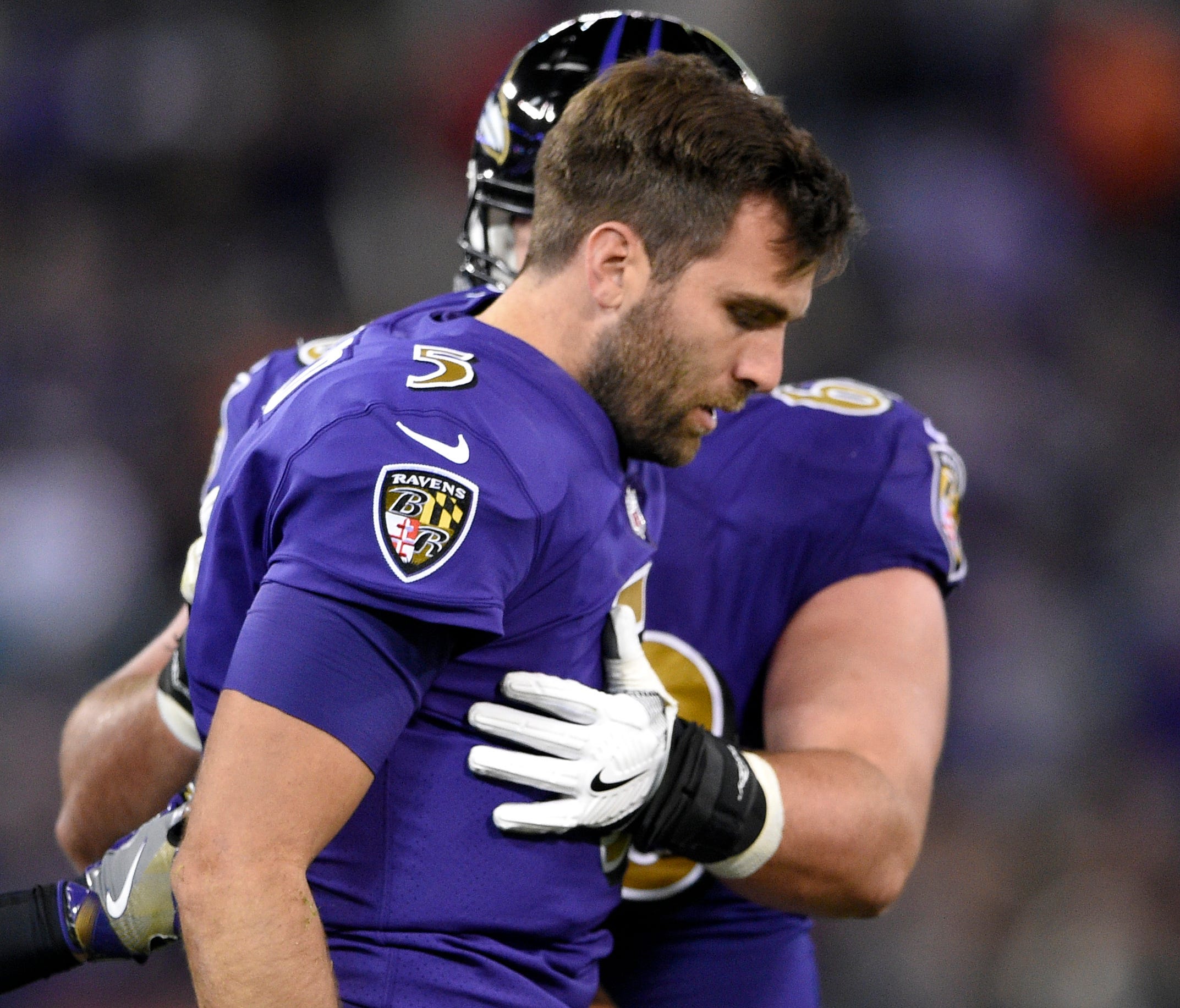 Baltimore Ravens quarterback Joe Flacco, right, is assisted off the field after being tackled by Miami Dolphins middle linebacker Kiko Alonso in the first half of an NFL football game, Thursday, Oct. 26, 2017, in Baltimore.