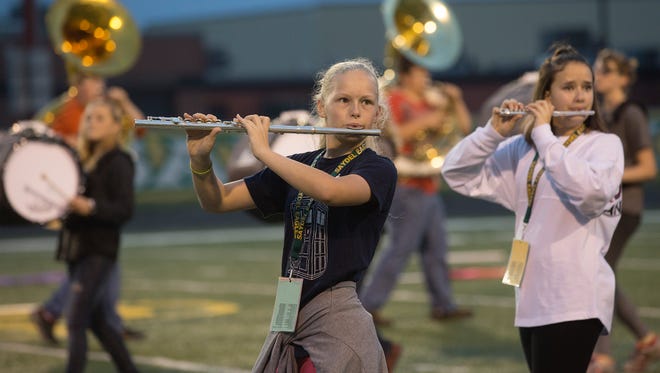 Eighth-grader Carolyn Rose plays the flute during a morning marching band practice at Saydel High School in Des Moines, Iowa, Thursday, Oct. 8, 2015. 