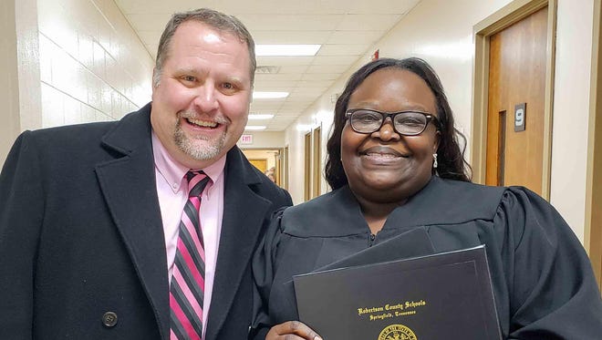 With Robertson County Director of Schools Chris Causey at her side, Springfield’s Latasha Cross shows off the high school diploma she earned after a 16-year struggle with math.