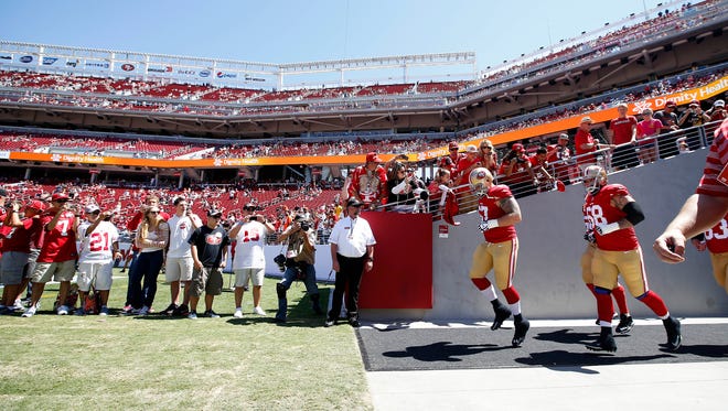 San Francisco 49ers players walk onto the field at Levi's Stadium before an NFL preseason football game against the Denver Broncos in Santa Clara, Calif., Sunday, Aug. 17, 2014. (AP Photo/Tony Avelar)