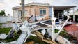 Roofs and car port materials litter the streets at