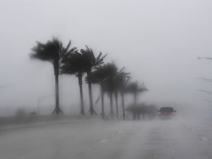 Commuters make their way through heavy rain in Jacksonville,