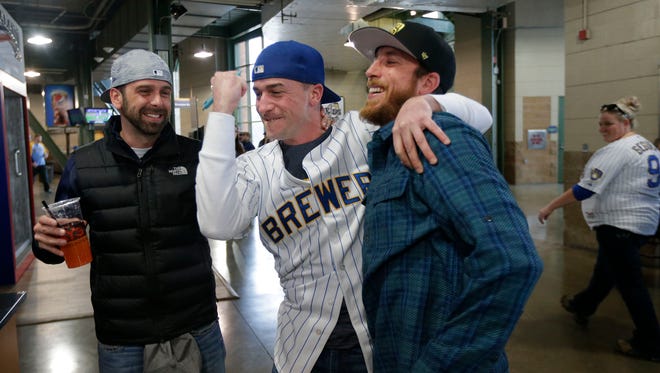 Former Milwaukee resident Patrick "P.J." Stich (center) of Grand Haven, Mich., celebrates winning $45,192 in the 50-50 raffle drawing Monday with his friends Tyson Burnett (right) of Madison and Jeff Hoeye of Fort Atkinson on opening day as the Brewers face the Rockies at Miller Park.