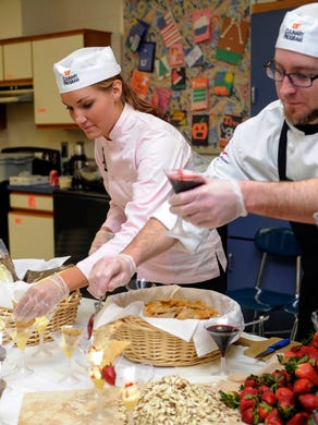 University of Tennessee Culinary Institute students Christie McCrory, left, and Brandon Wilson prepare Italian custard desserts during a catered appreciation lunch for teachers at West High School Tuesday, April 2, 2013.