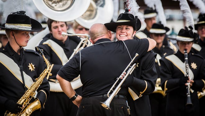 Band director Douglas Fletcher hugs Winchester band members before preliminaries at the Indiana State Fair Saturday.  Fletcher retired as band director following the Band Day competition. 