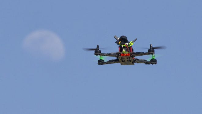 Doug Andriuk, co-founder, of Revolution UAS, flies his drone at Thude Park in Chandler as the moon rises on June 26, 2015.