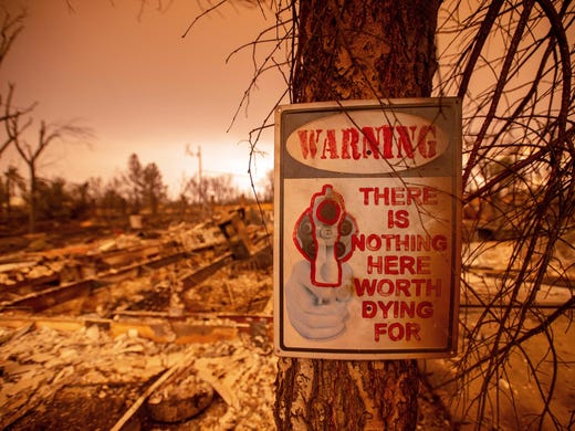 A sign is seen posted at a burned residence during