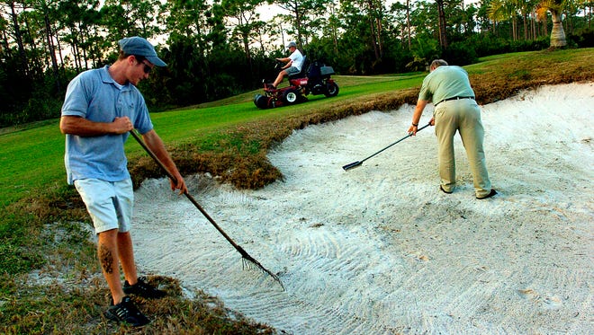 In this file photo, Indian River State College students rake the sand traps and mow the fairway during a golf course class designed to build careers in golf course maintenance and operations.