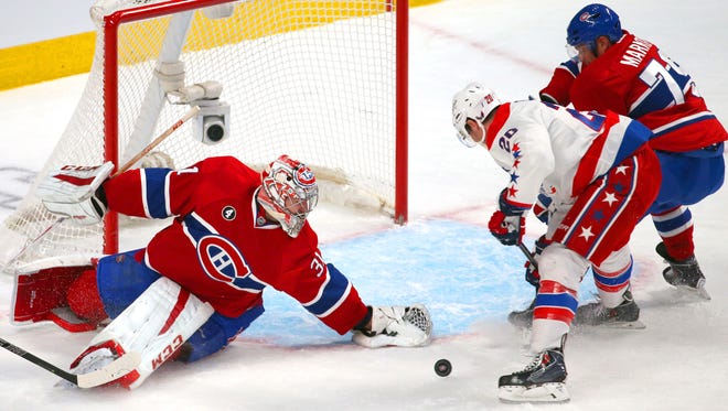 Montreal Canadiens goalie Carey Price makes a save against Washington Capitals right wing Troy Brouwer as  defenseman Andrei Markov defends during the second period at Bell Centre.