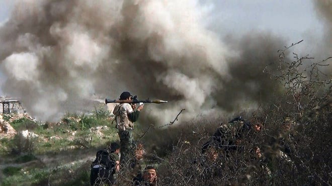 An image grab taken from a video shows an opposition fighter holding a rocket-propelled grenade launcher as his fellow comrades take cover from an attack by regime forces on Aug. 26.