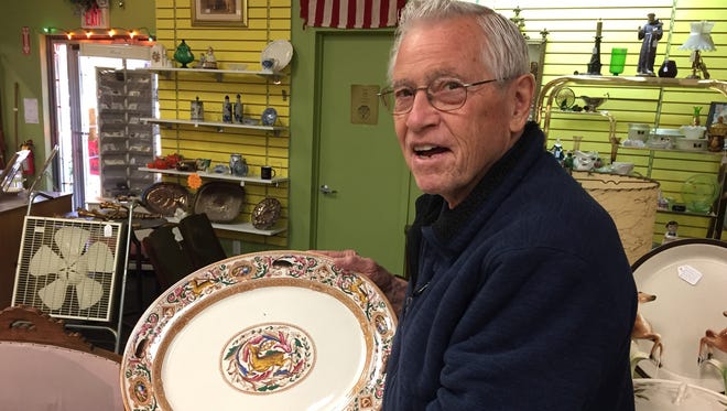 Mike Gaylord holds a rare Rienzi stag and boar platter, part of a set for sale at Angels Among Us Antique Mall in St. Clair. Gaylord is going out of business and a restaurant will move into his space in the Riverview Plaza.