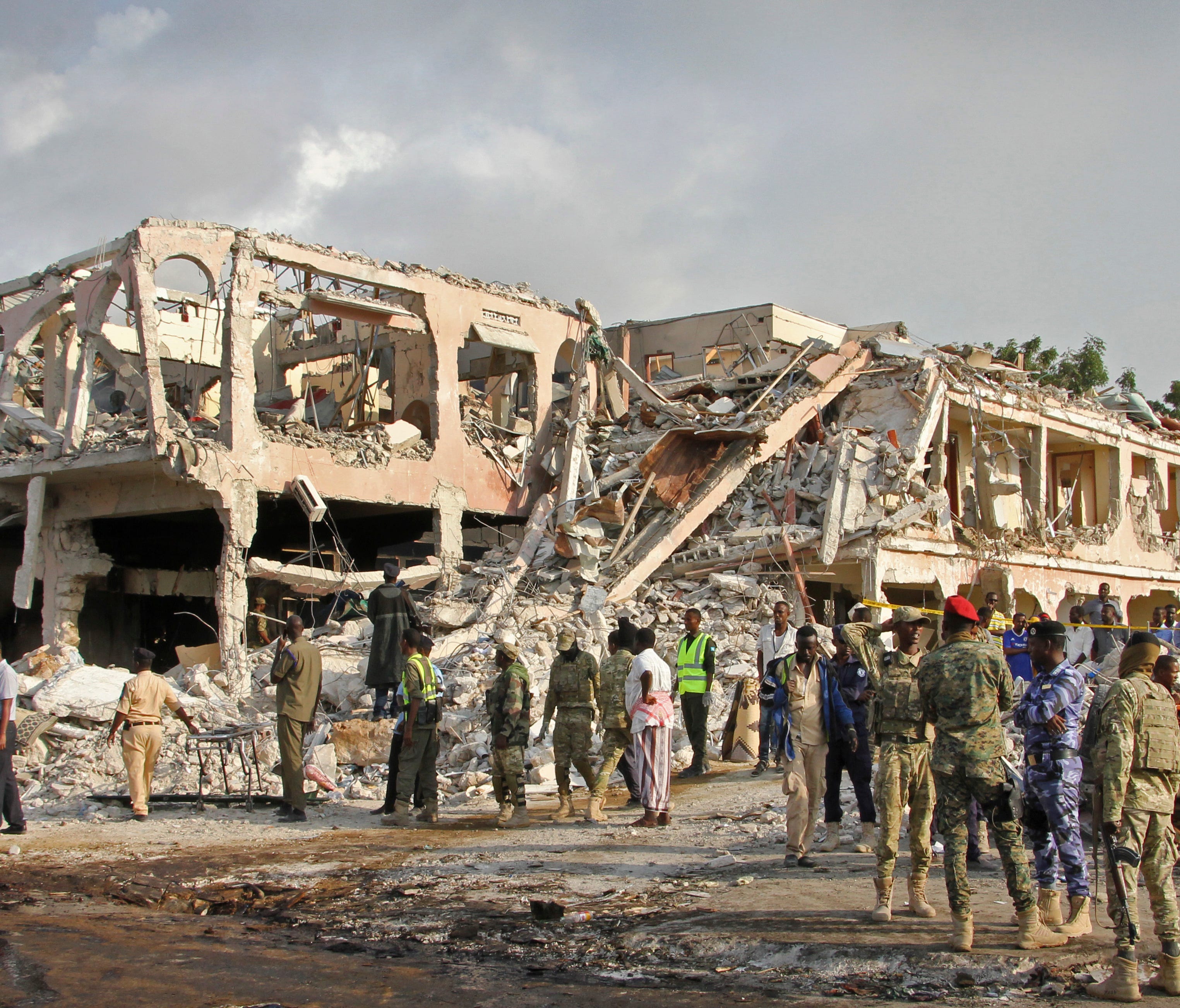 Somali security forces and others gather and search for bodies near destroyed buildings at the scene of Saturday's blast, in Mogadishu, Somalia, on Oct. 15, 2017.
