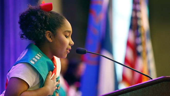 Girl Scout Alisha Irizarry, 8, of Rochester asks everyone to join her in the Pledge of Allegiance during the Girl Scouts Leadership Luncheon at the Hyatt Regency Rochester.