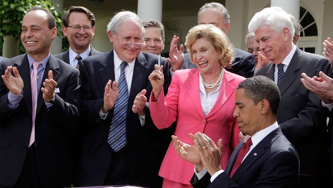 Rep. Carolyn Maloney, D-N.Y., holds up a pen used by President Obama to sign the Credit Card Accountability, Responsibility, and Disclosure Act in the Rose Garden at the White House on May 22, 2009.