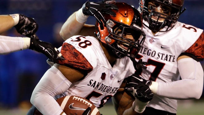 San Diego State defensive lineman Alex Barrett (58) celebrates his interception with teammate Ryan Dunn during the second half of an NCAA college football game against San Jose State on Saturday, Oct. 17, 2015, in San Jose, Calif. San Diego State won 30-7.