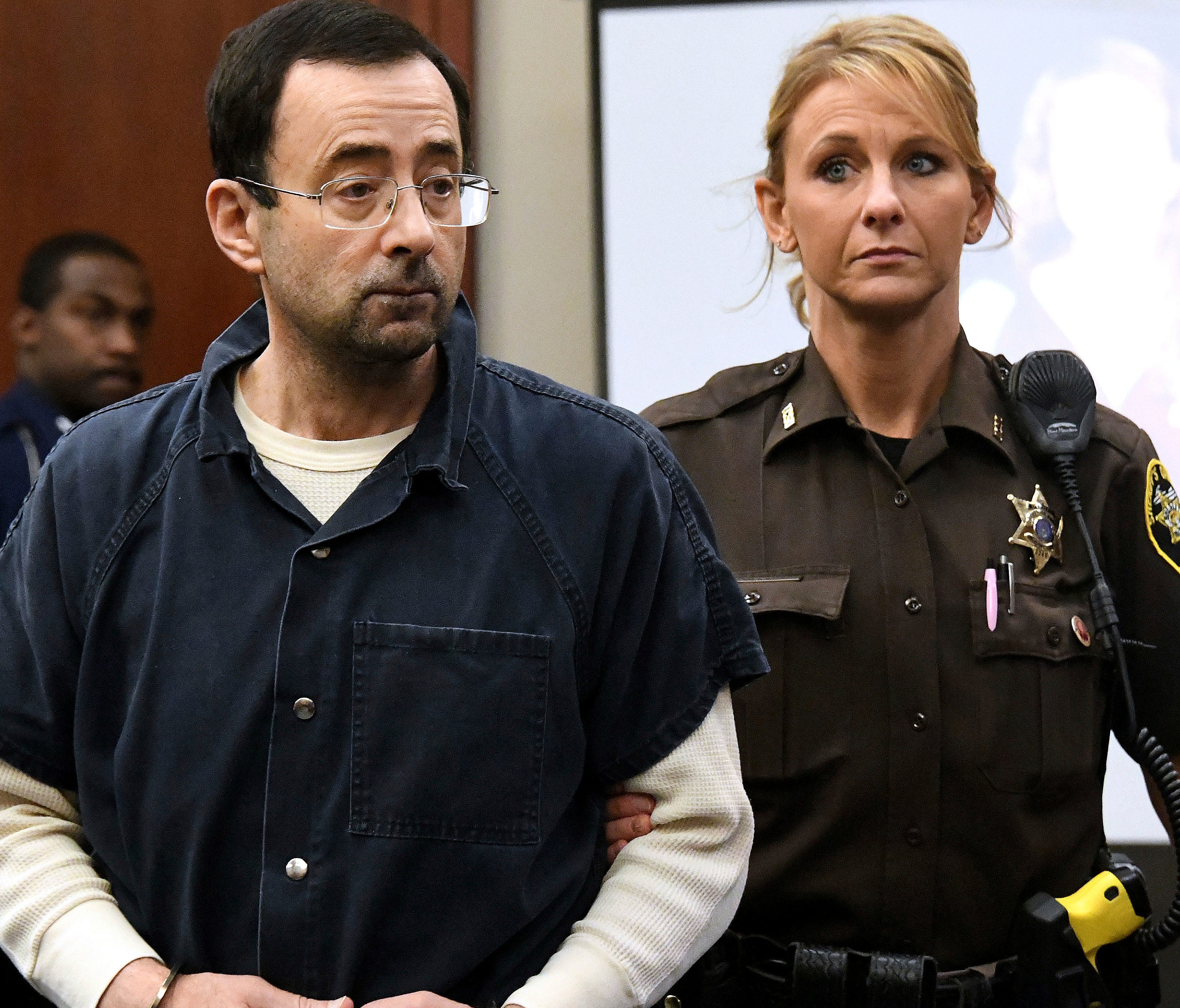 Larry Nassar is pictured being escorted into the courtroom in Lansing, Mich.