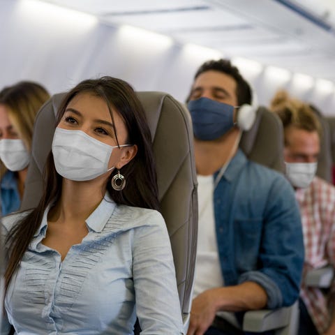 A woman wears a face mask while traveling on an ai