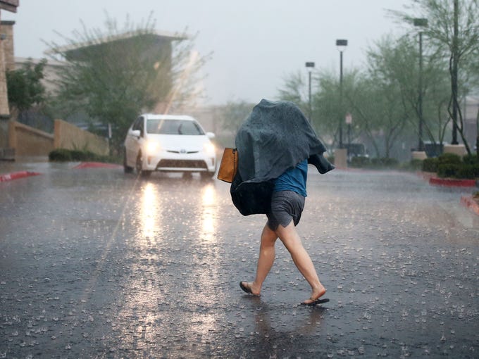 A shopper makes for cover in a monsoon rain storm on
