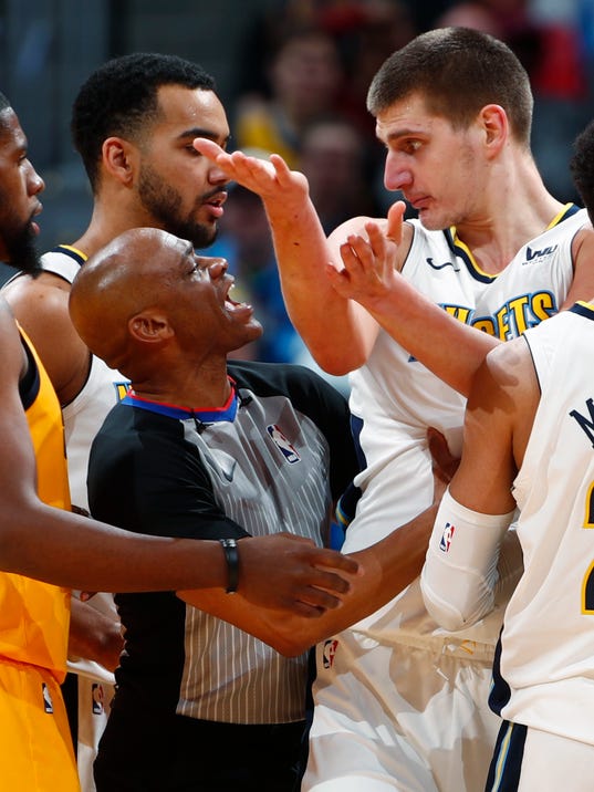 Referee Tre Maddox, left, controls Denver Nuggets center Nikola Jokic, of Serbia, after he was assessed a flagrant foul against Utah Jazz forward Jonas Jerebko in the second half of an NBA basketball game Tuesday, Dec. 26, 2017, in Denver. Jokic was ejected from the game. The Nuggets won 107-83. (AP Photo/David Zalubowski)