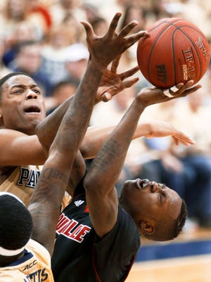 Pittsburgh's Chris Jones, left, fouls Louisville's Terry Rozier as he shoots in the second half of an NCAA college basketball game Sunday, Jan. 25, 2015, in Pittsburgh. (AP Photo/Keith Srakocic)