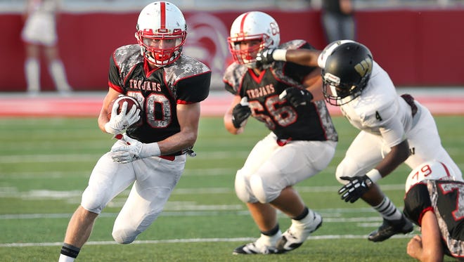 Center Grove running back Titus McCoy finds a big hole in the Warren Central defense during the season opener held at Center Grove High School on Friday, August 22, 2014.