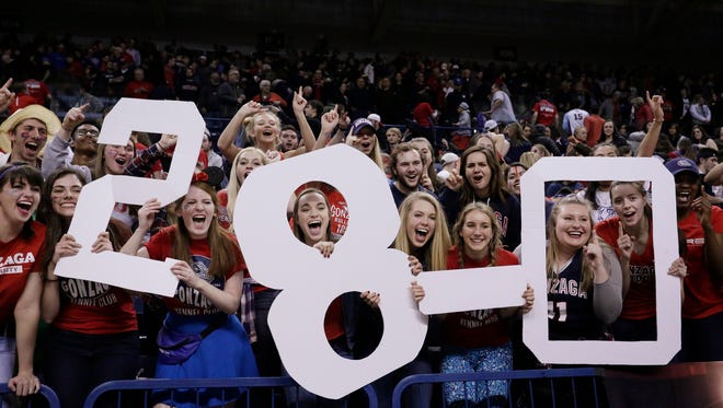 Fans in the Gonzaga student section hold signs that read "28-0",