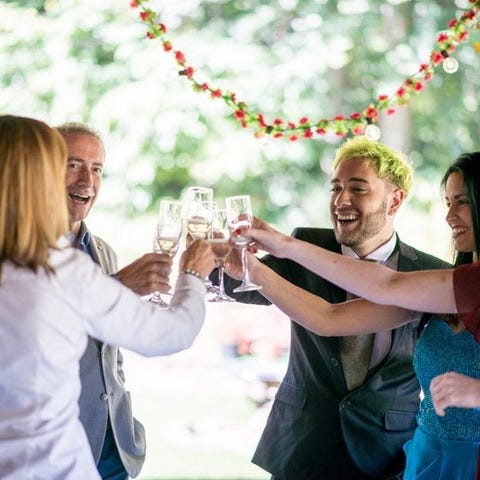 A group of wedding attendees in formal attire smil