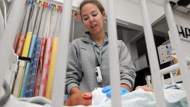 Amanda Critser, registered nurse, works with a baby in the Neonatal Intensive Care Unit Wednesday at Nationwide Children's Hospital in Columbus.