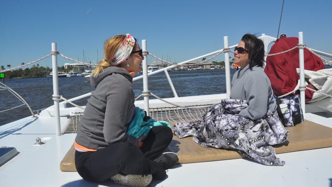 Kelly Dallaire and Angie Torres enjoy the boat ride back to port aboard the Sweet Liberty after doing yoga on Keewaydin Island.