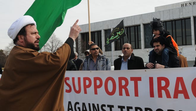 Imam Husham Al-Husainy, director of the Karbalaa Islamic Education Center in Dearborn, leads demonstrators in chants such as “No more ISIS in Iraq” and “Stop the terrorists in Iraq” on Friday. The nearly two-hour demonstration ws held in front of the Henry Ford Centennial Library.