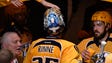 A fan taps the head of Nashville Predators goalie Pekka