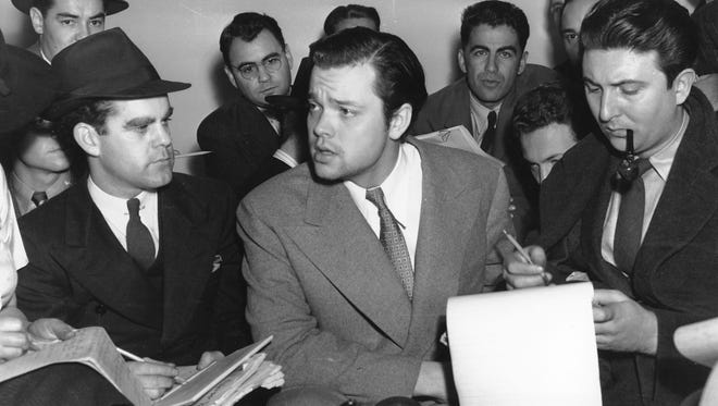 Orson Welles, center, explains to reporters on Oct. 31, 1938 his radio dramatization of H.G. Wells' "War of the Worlds."  Meanwhile, Columbia Broadcasting System made public the transcript of the dramatization, which was aired the night of Oct. 30 and caused thousands of listeners to panic because of the realistic broadcast of an imaginative invasion of men and machines from Mars.