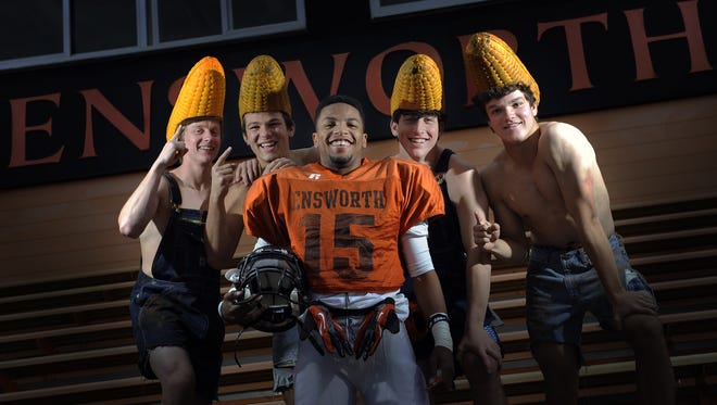 Ensworth running back Corn Elder is surrounded by classmates Peter Spruill, Hutt Cooke, Michael Buttarazzi and Jack Nesbitt, who wear corn cob-shaped hats to show their support for Elder during football games in 2012.