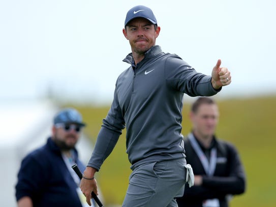 Rory McIlroy acknowledges fans after hitting from the