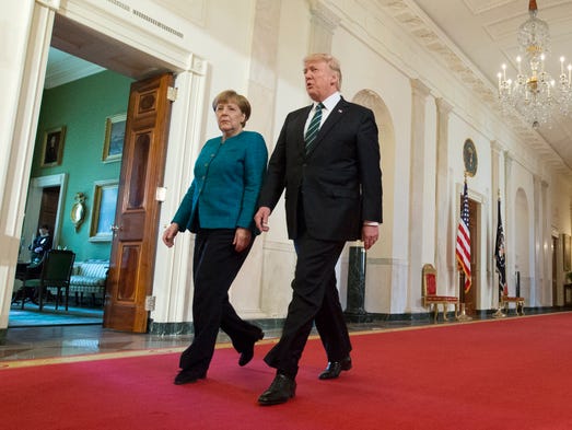 Trump and German Chancellor Angela Merkel walk down