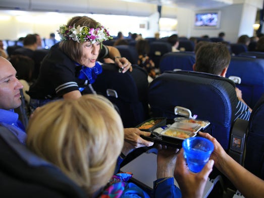 Crew members serve meals to passengers aboard the last