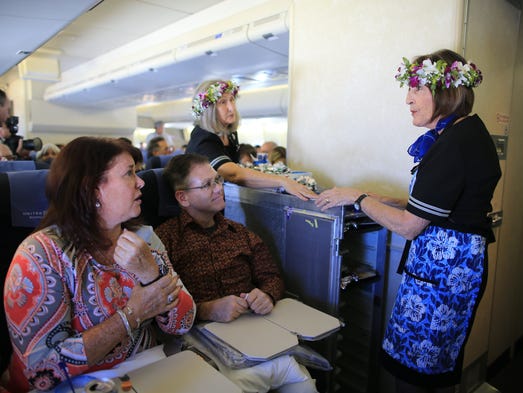 Crew members serve meals to passengers aboard the last