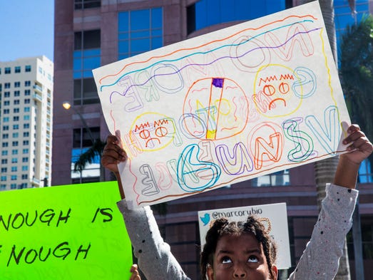 Andrea Shawfiele, 10, looks up at her handmade sign