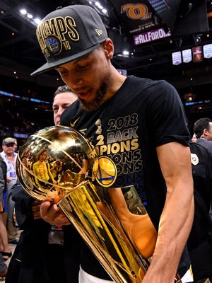 Stephen Curry celebrates with the Larry O'Brien Championship Trophy after beating the Cleveland Cavaliers in Game 4 of the 2018 NBA Finals.